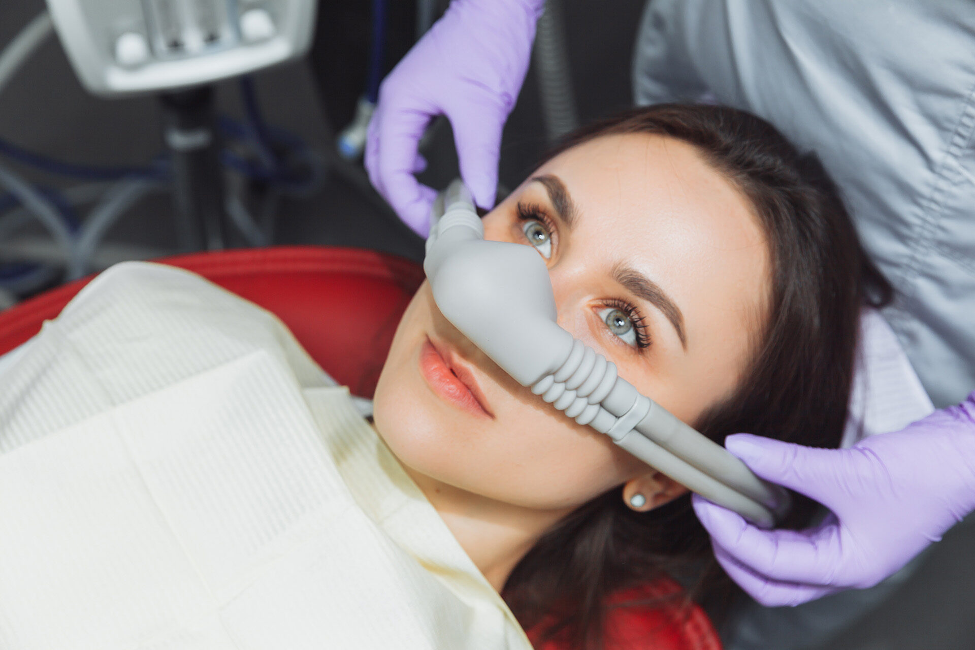 woman in dentist chair wearing sedative mask before procedure