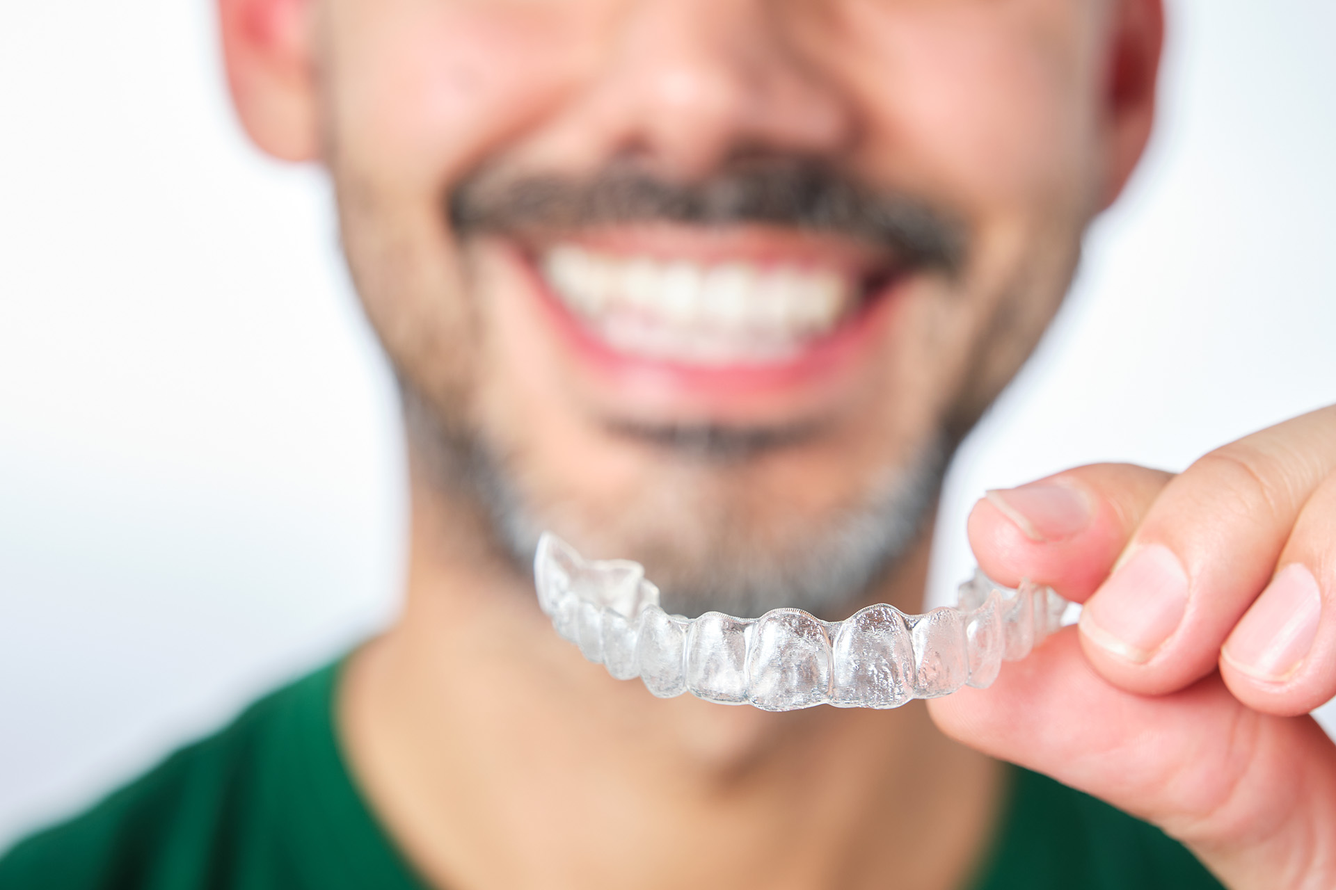 man holding transparent dental retainer
