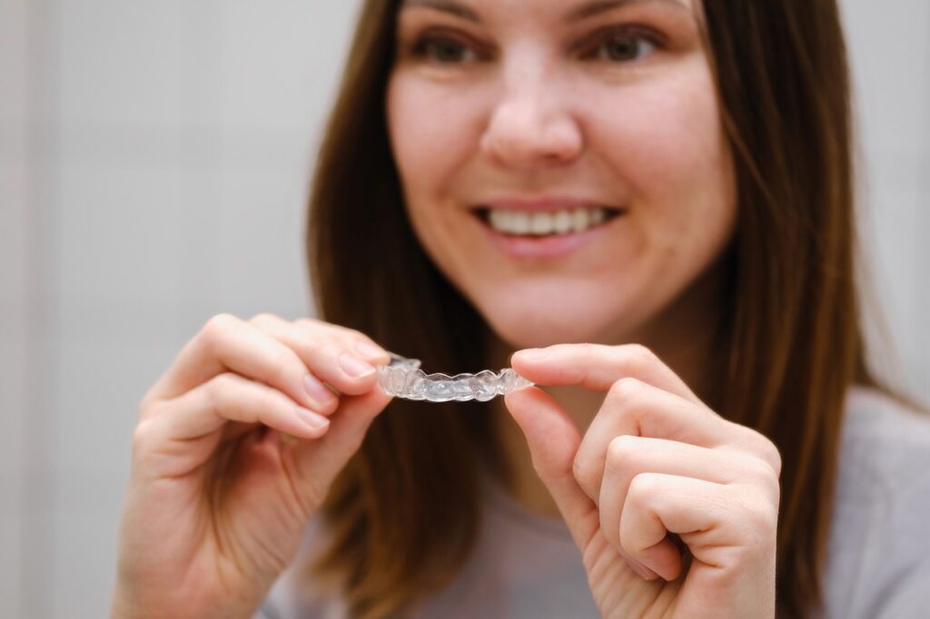 Close up of a woman holding her Invisalign retainer